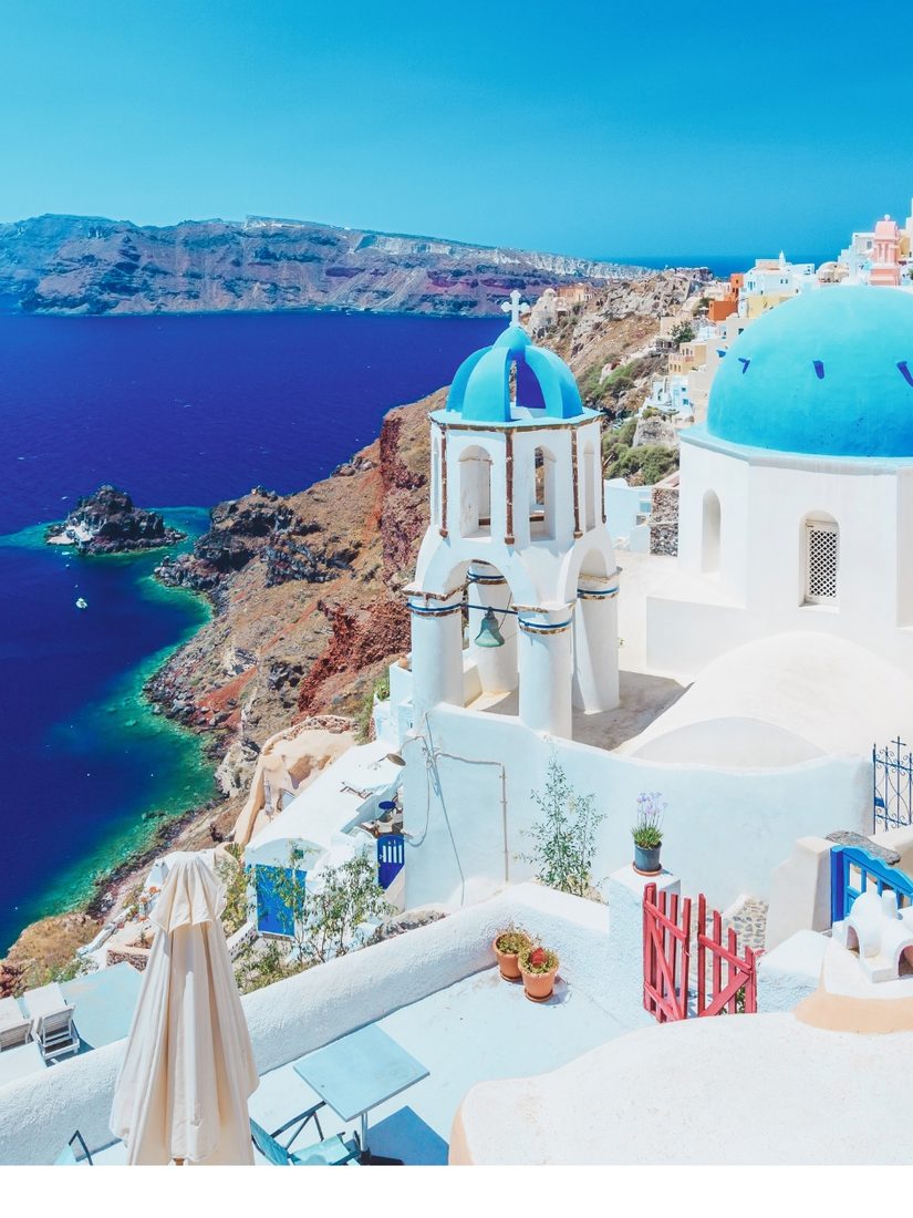 Blue-domed white churches above the sea in Santorini, Greece